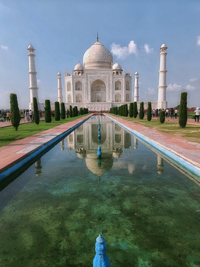 services-03 Stunning view of the Taj Mahal with its reflection in Agra, India, under a clear blue sky.